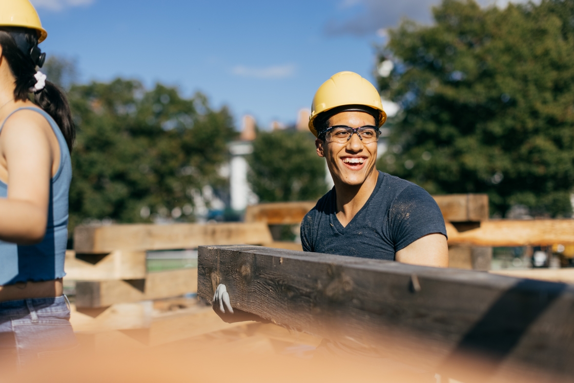 A student helps build the bonfire for Dartmouth homecoming