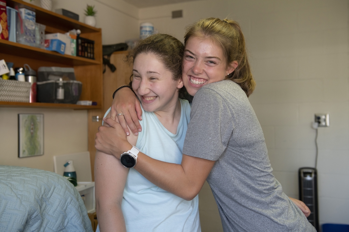 Two students hug each other