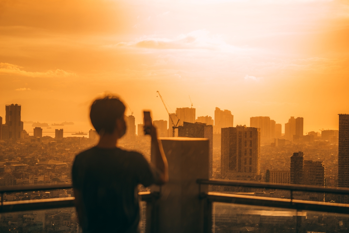 ): A person using a phone looks out at Manila, the capital of the Philippines.