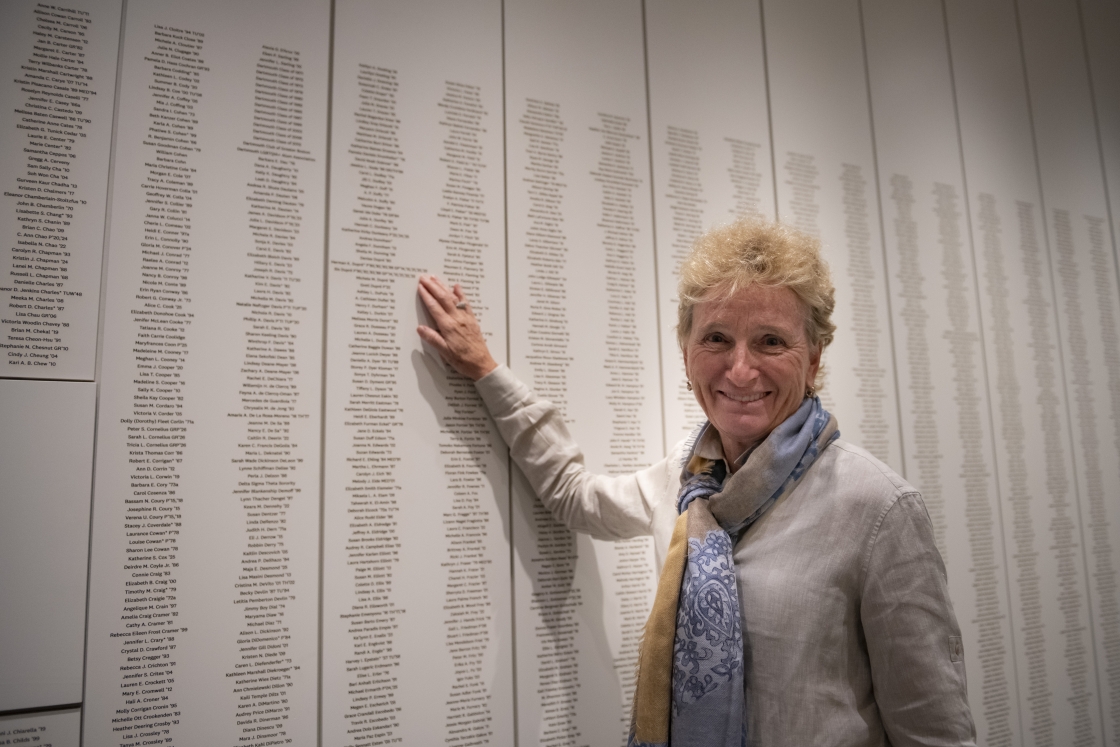 Person stands in front of dedication wall