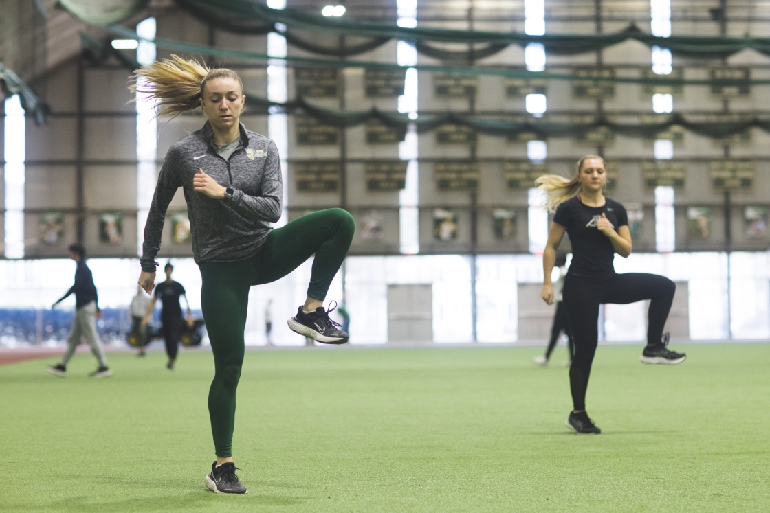 Michelle Quinn and Shelby Richmond doing dynamic stretches