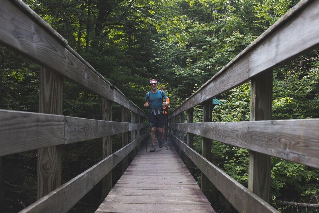 Wyatt Ellison and others hike across a bridge