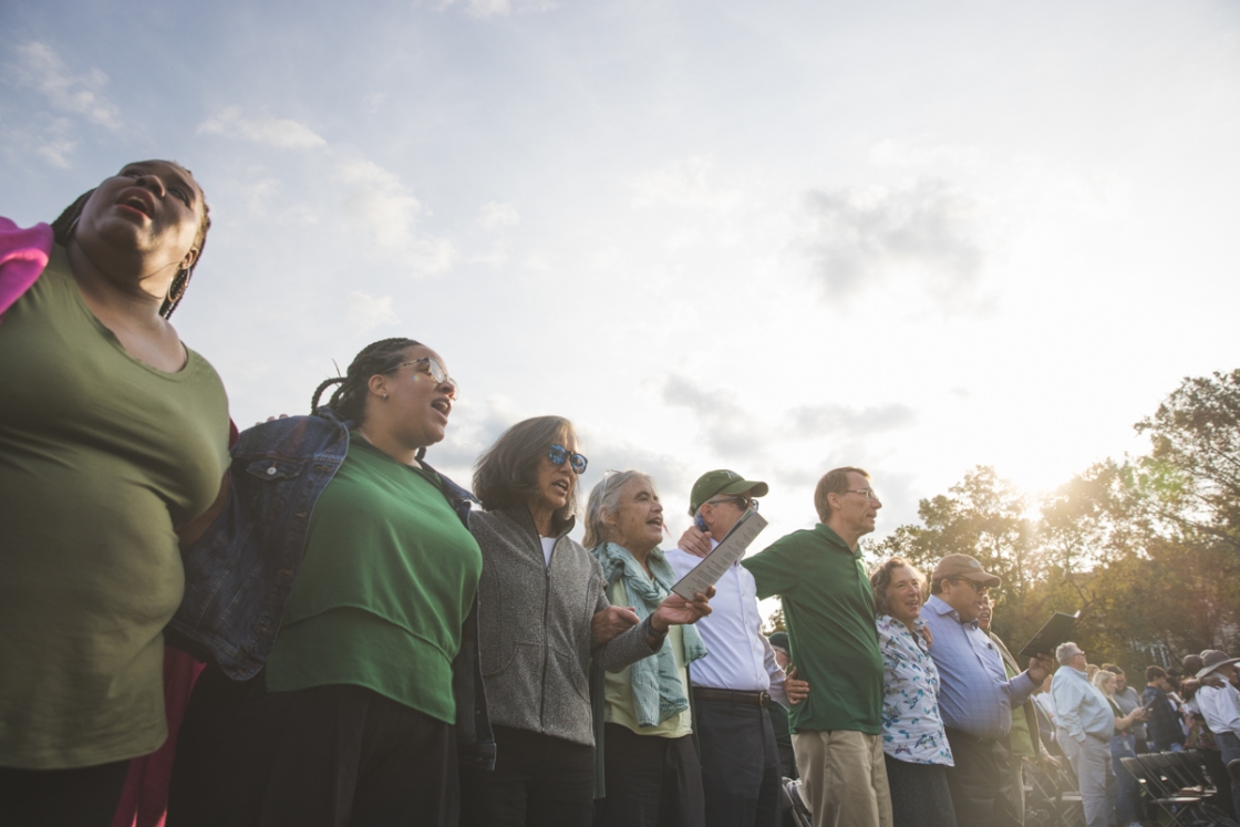 Community members sings the alma mater