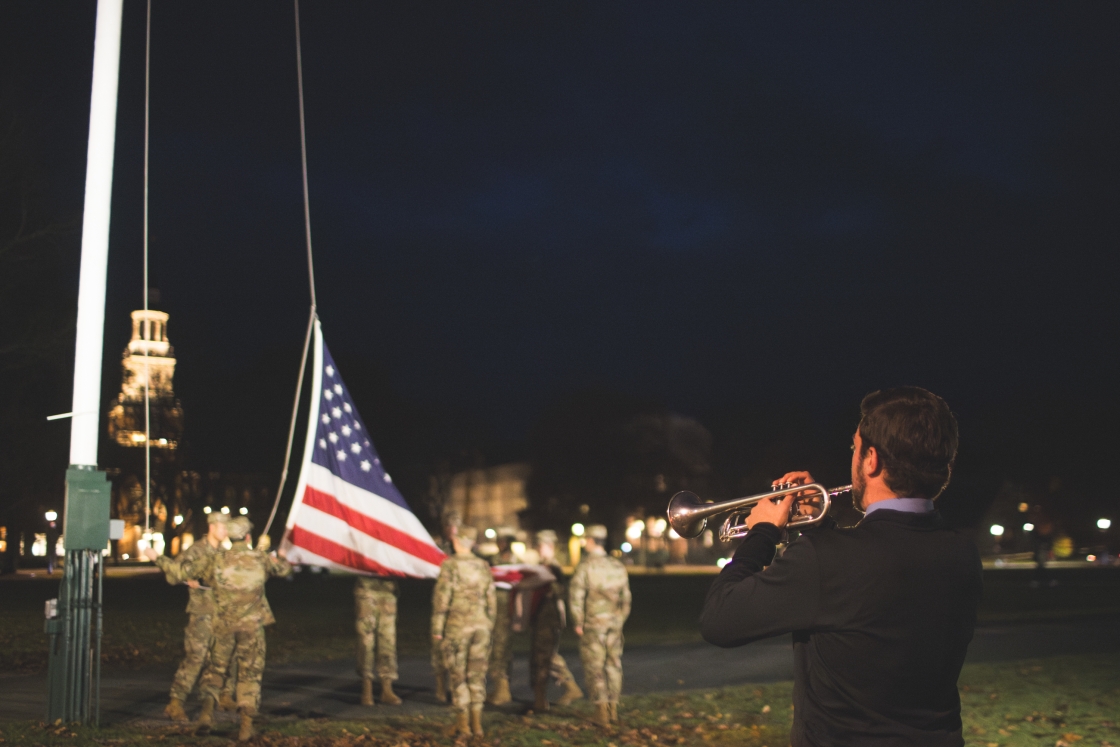 Jacob Crawford playing the trumpet while ROTC lowers the flag