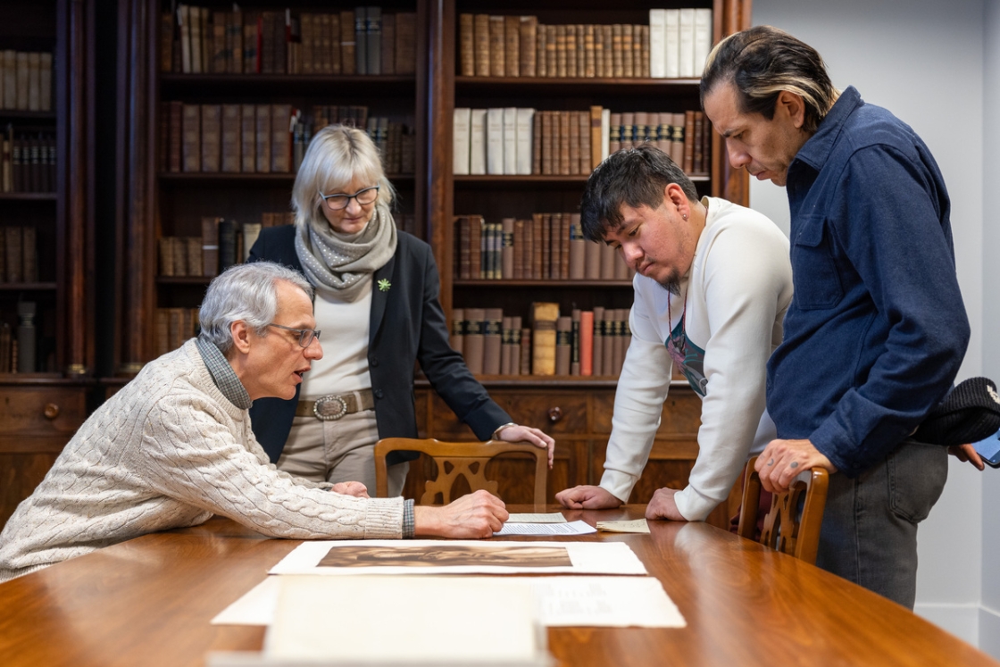 Osage visitors and library staff look at a letter and photograph in Rauner Special Collections Library.