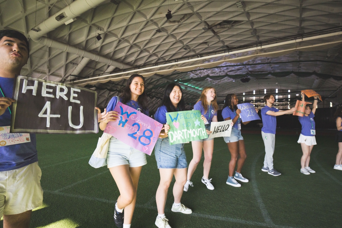 Orientation Leaders hold welcome signs.