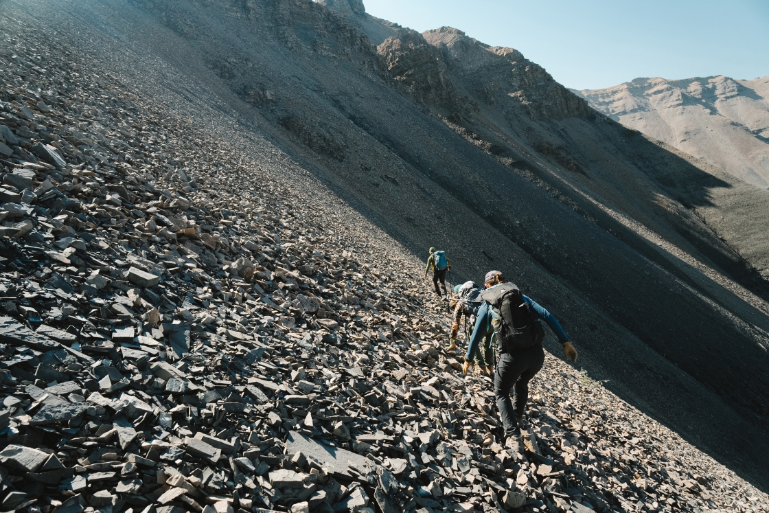 Dartmouth researchers on a mountainside with loose gravel