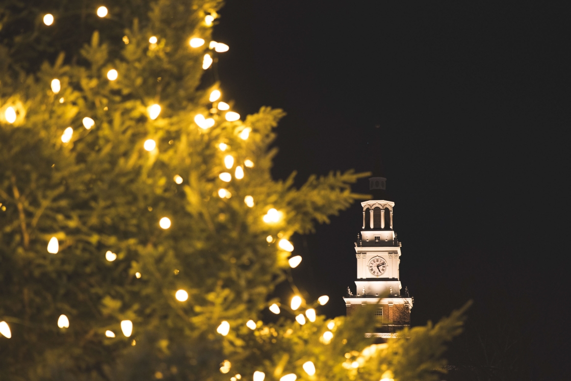 Christmas tree branches frame Baker Tower at night