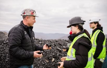 Doug Fala speaks to Constance Legrand and Luc Cote, wearing safety vests and hard hats