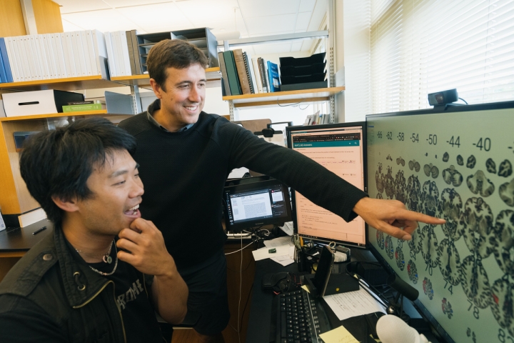 Michael Sun and Tor Wager looking at a computer
