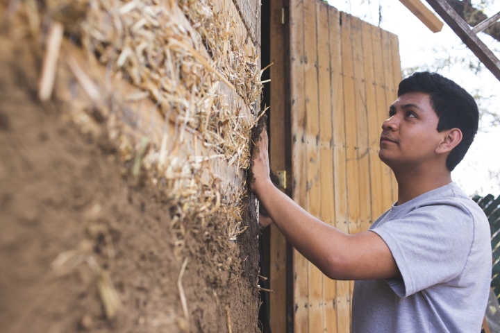 Sergio Campos using his hand to spread superadobe to a wall