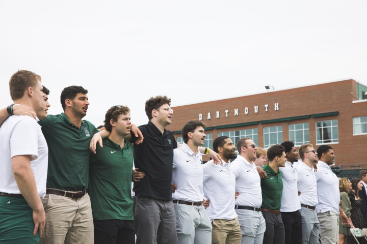 Football players stand arm and arm singing