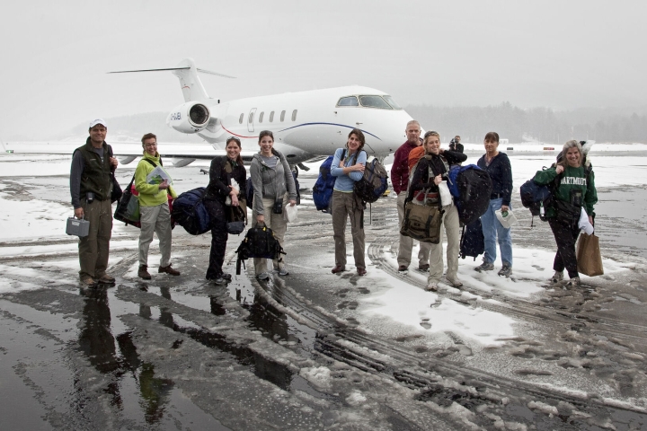 A group of people outside of a jet in the snow