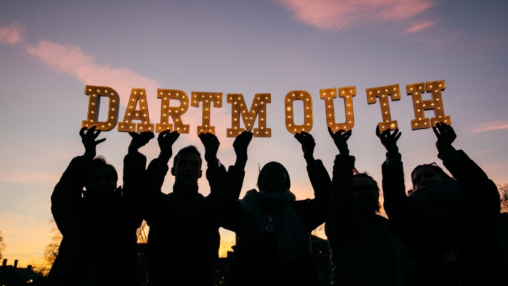 students hold up an Admissions sign