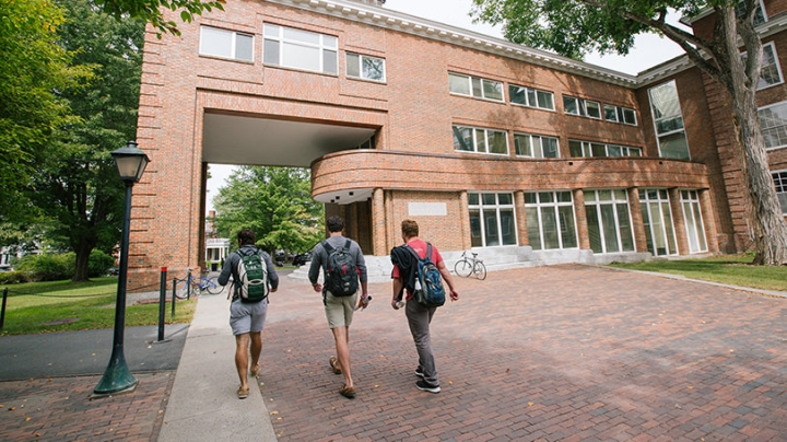 Three students walk toward Rockefeller Hall