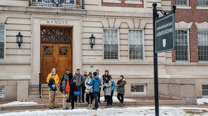 a group of prospective students gathered outside the admissions building at the start of a tour