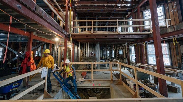 construction workers climbing a ladder inside the hollowed-out Morton Hall