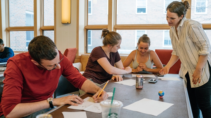Line Hoven with a group of students seated around a table drawing