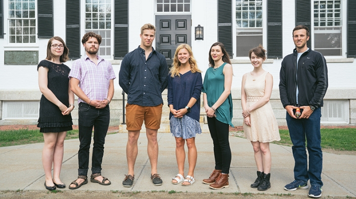 a group of students standing together outside of a white building