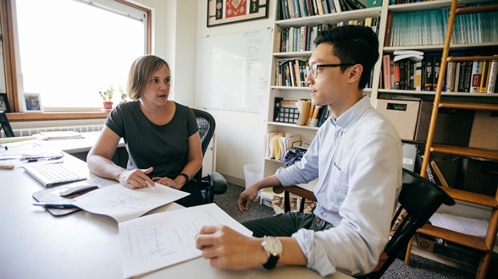 two people sitting at a desk in an office