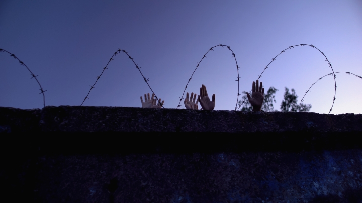 Wall with hands over the top.