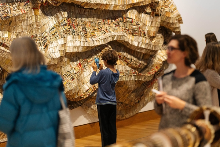 Child taking a photo of wall hung art