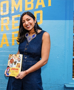 Priya Krishna holding a copy of her book