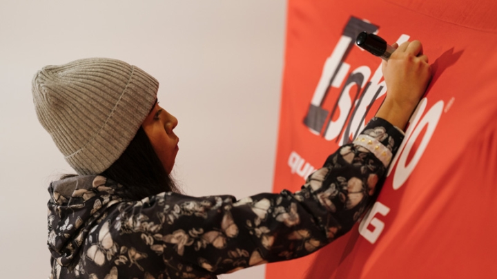 Gabe Canfield '21 replaces the label on a portable darkroom tent with &quot;Iñupiat,&quot; the tribe she belongs to.